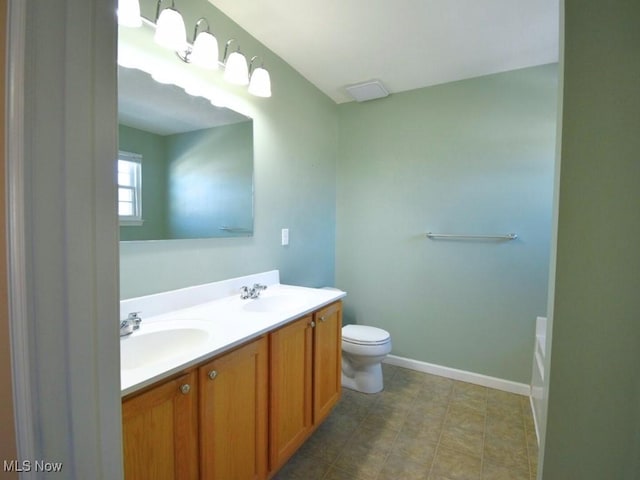 bathroom with vanity, a bathing tub, and toilet