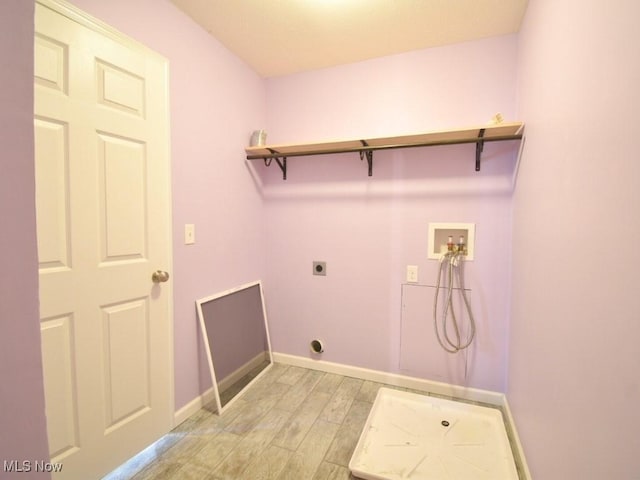 washroom with hookup for an electric dryer, washer hookup, and light wood-type flooring