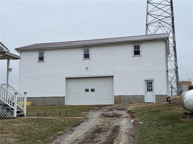 back of house with a garage and a lawn