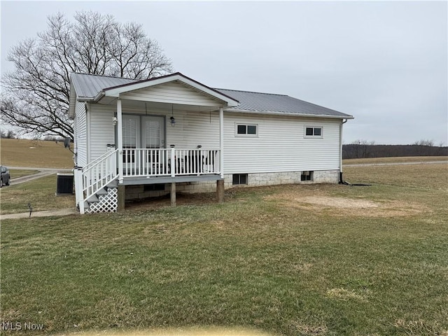 exterior space with central air condition unit, covered porch, and a front lawn