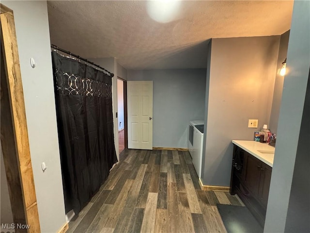 bathroom featuring washer / clothes dryer, wood-type flooring, vanity, and a textured ceiling