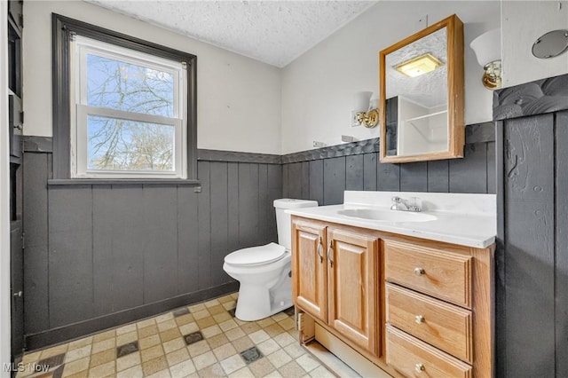 bathroom with vanity, toilet, and a textured ceiling