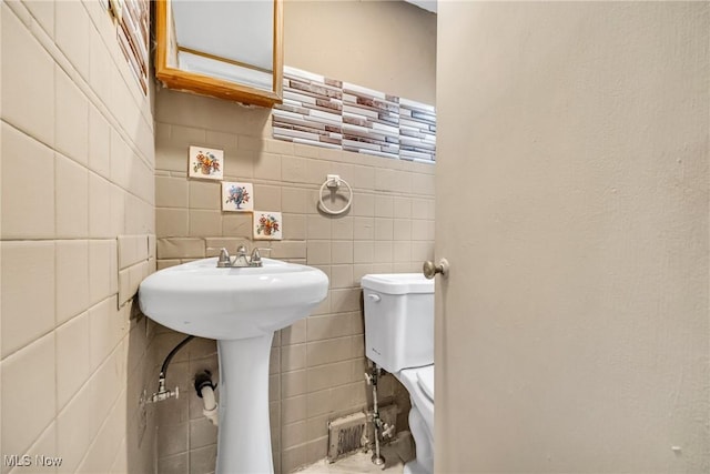 bathroom featuring tile walls and toilet