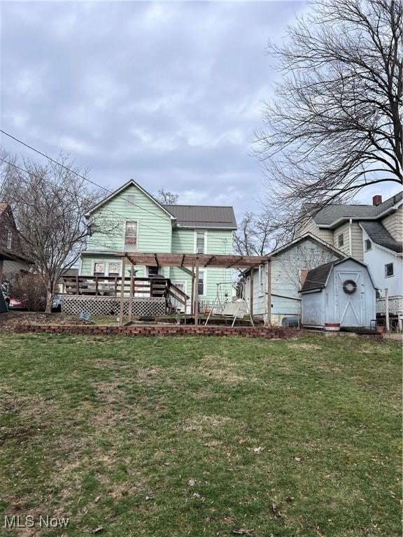 rear view of property with a yard and a deck