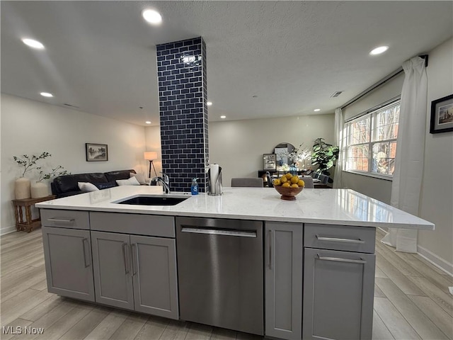 kitchen featuring gray cabinets, light stone countertops, sink, and stainless steel dishwasher