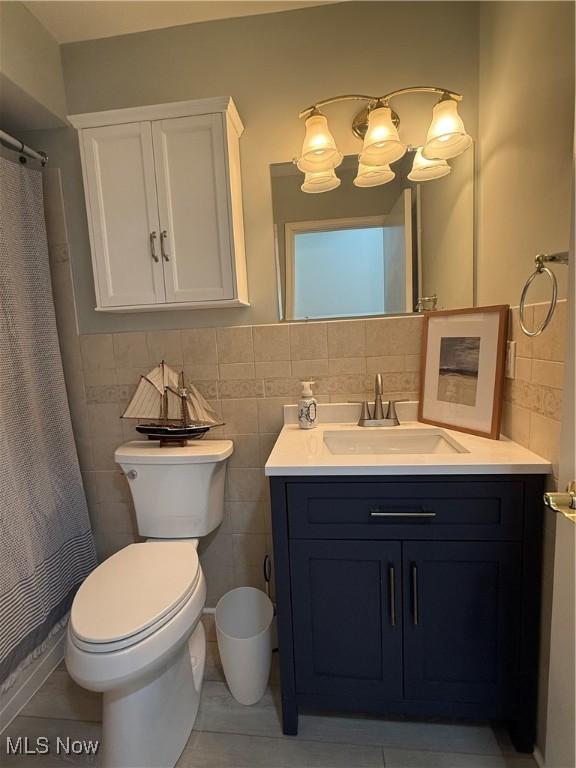 bathroom featuring tile walls, vanity, a shower with curtain, and toilet