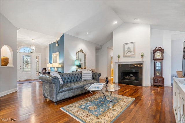 living room featuring a tiled fireplace, high vaulted ceiling, hardwood / wood-style floors, and an inviting chandelier