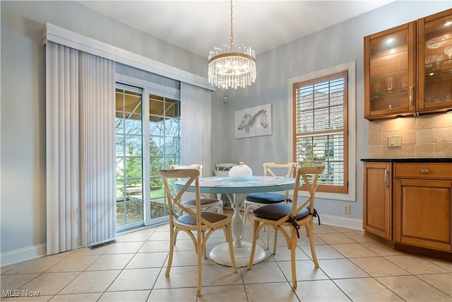 dining area with light tile patterned floors, a notable chandelier, and plenty of natural light