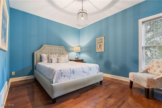 bedroom featuring hardwood / wood-style floors and an inviting chandelier