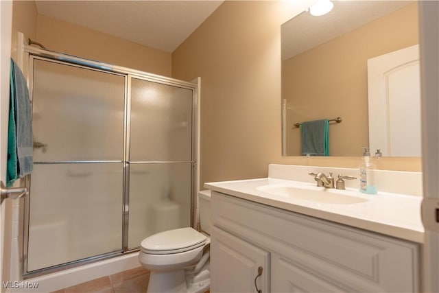 bathroom with vanity, a shower with shower door, tile patterned floors, and toilet