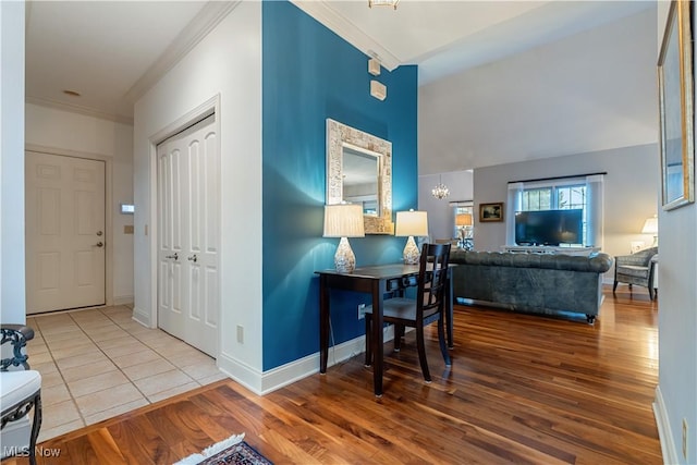 dining room featuring lofted ceiling, hardwood / wood-style flooring, ornamental molding, and a chandelier