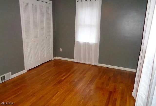 unfurnished bedroom with wood-type flooring and a closet