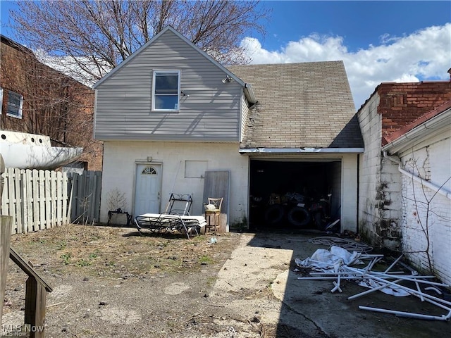 rear view of property with a garage