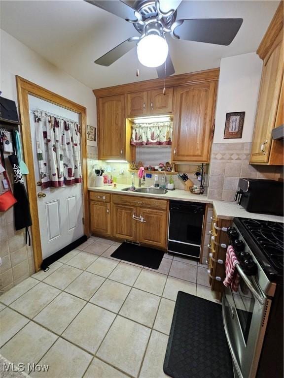 kitchen featuring sink, light tile patterned floors, decorative backsplash, and black appliances