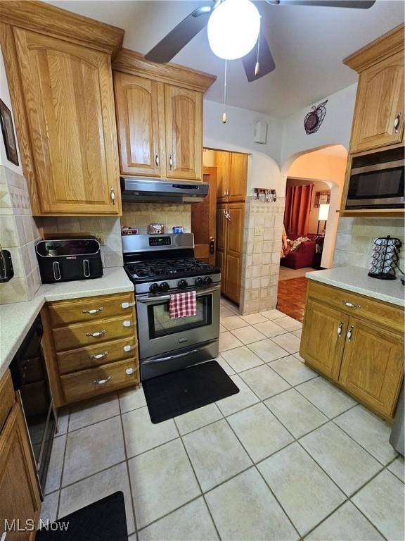 kitchen featuring stainless steel appliances, light tile patterned flooring, ceiling fan, and decorative backsplash