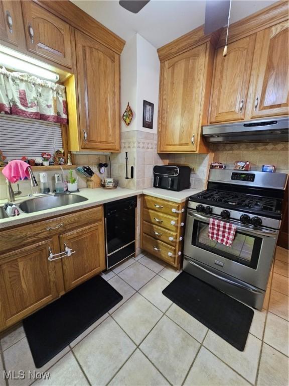 kitchen with sink, light tile patterned floors, dishwasher, tasteful backsplash, and gas stove