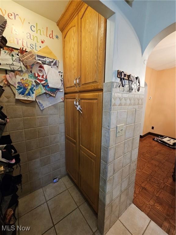 bathroom with tile patterned floors and tile walls