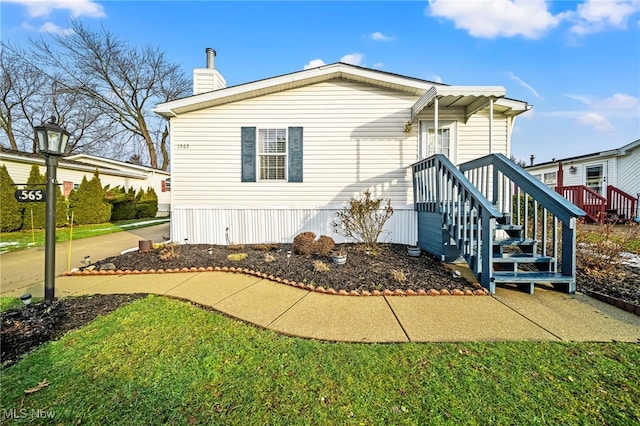 manufactured / mobile home featuring a front lawn