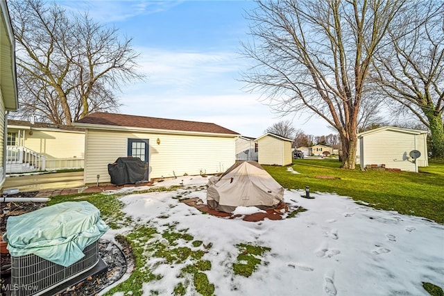 yard layered in snow with a storage unit