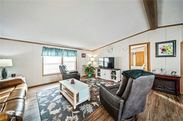 living room featuring lofted ceiling with beams, wood-type flooring, and ornamental molding