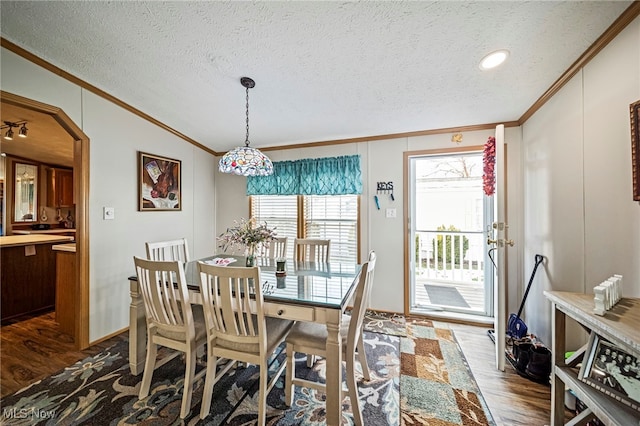 dining room featuring crown molding, hardwood / wood-style floors, and a textured ceiling