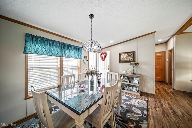 dining room featuring dark hardwood / wood-style flooring, ornamental molding, a textured ceiling, and lofted ceiling