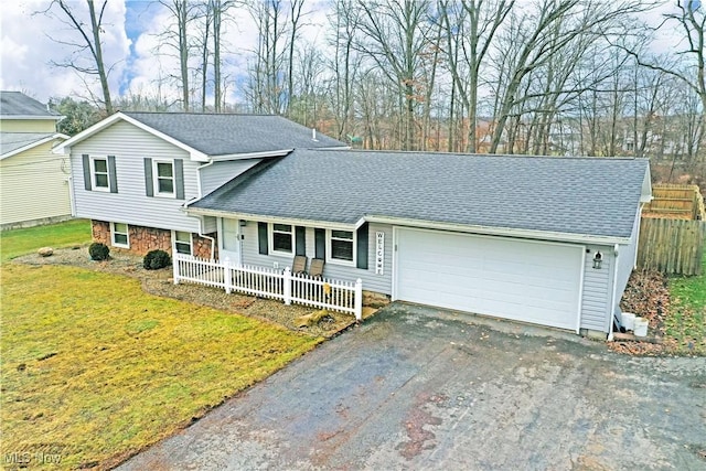 tri-level home featuring a garage, a front lawn, and a porch