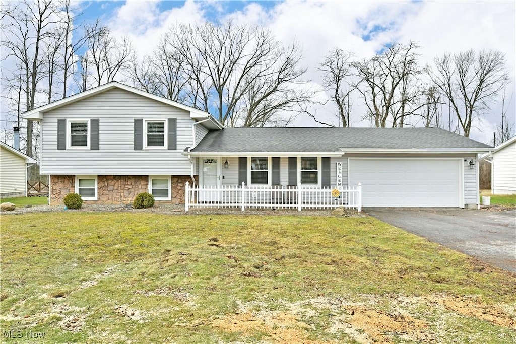 tri-level home featuring a garage and a front lawn