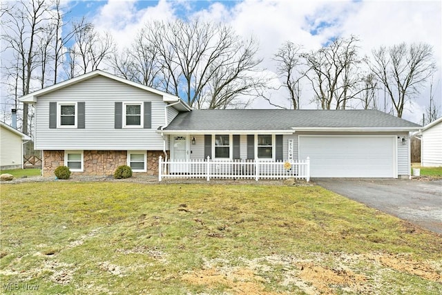 tri-level home featuring a garage and a front lawn