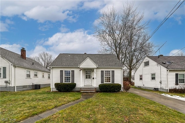 bungalow-style home featuring cooling unit and a front yard