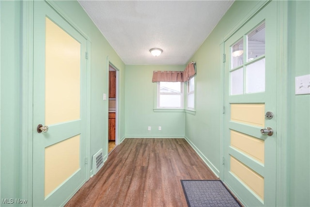 doorway with hardwood / wood-style floors and a textured ceiling