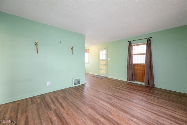 spare room with hardwood / wood-style flooring and a textured ceiling