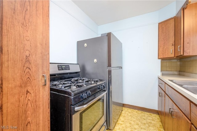 kitchen with tasteful backsplash, sink, and stainless steel gas stove