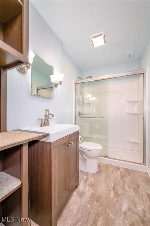 bathroom with vanity, toilet, and an enclosed shower