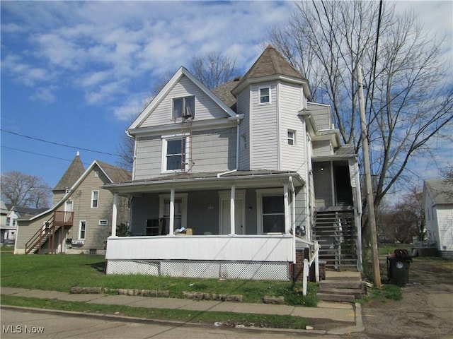 victorian-style house featuring a porch and a front yard