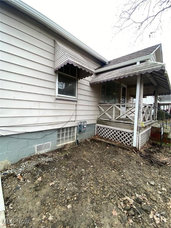 view of side of home featuring covered porch