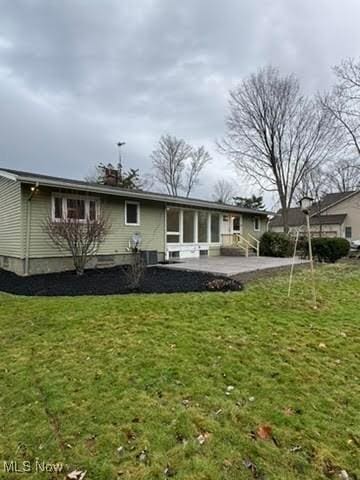 back of property featuring a patio area and a lawn