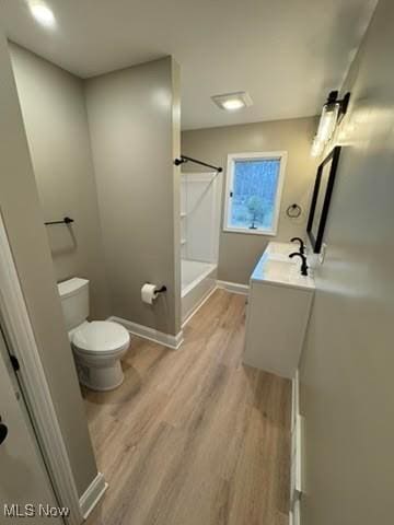 full bathroom with hardwood / wood-style flooring, vanity, toilet, and bathtub / shower combination