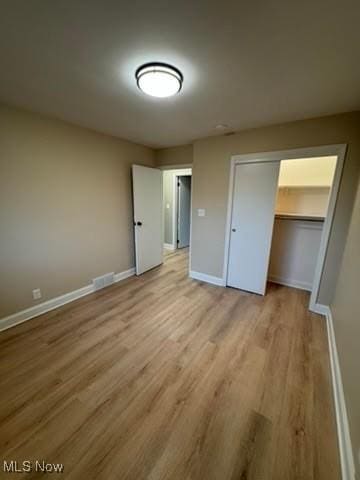 unfurnished bedroom featuring light wood-type flooring and a closet