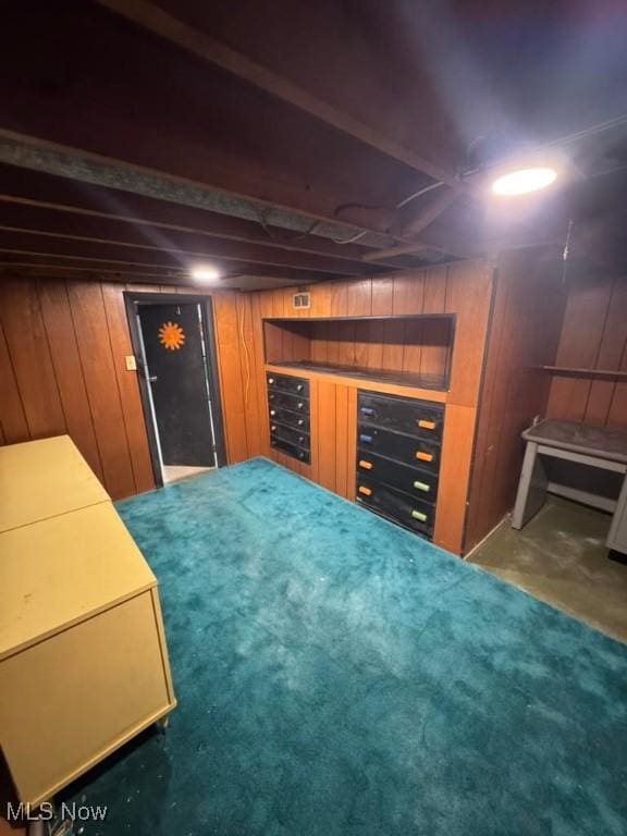 basement with a mail area and wood walls