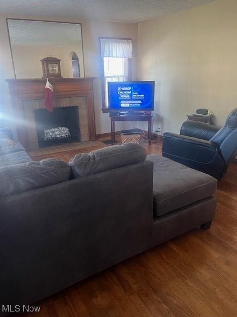 living room with a tile fireplace and hardwood / wood-style floors