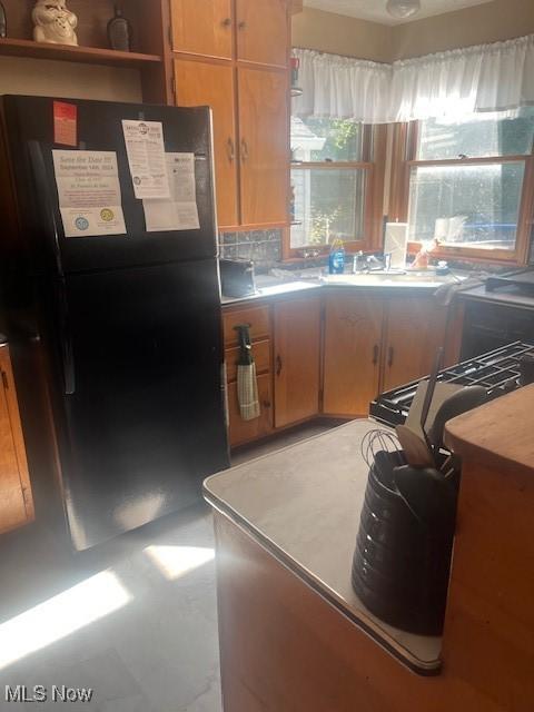 kitchen featuring black fridge and sink