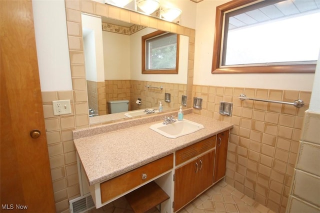 bathroom with tile walls, vanity, tile patterned floors, and toilet