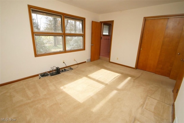 unfurnished bedroom featuring light carpet and a closet