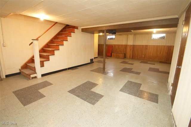 basement featuring wooden walls