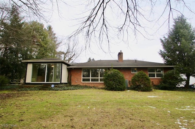 rear view of property with a sunroom and a lawn