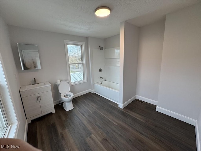 full bathroom with  shower combination, vanity, wood-type flooring, a textured ceiling, and toilet