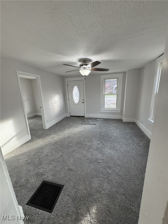 interior space with ceiling fan and a textured ceiling