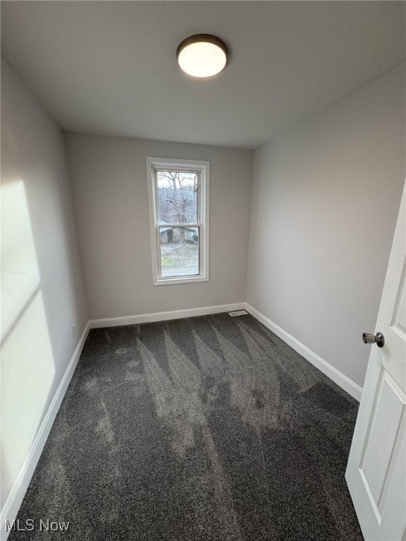 empty room with dark colored carpet