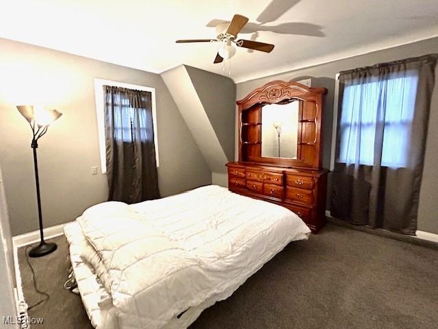 carpeted bedroom with a ceiling fan and baseboards